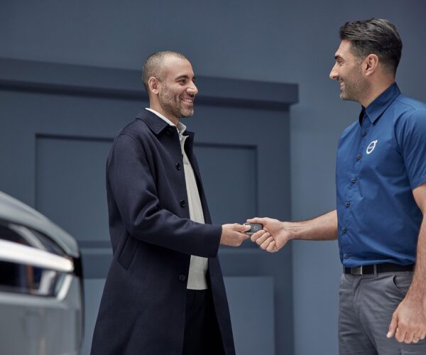 Acheteur recevant les clés d’une voiture d’un vendeur en concession, symbole de la vente automobile