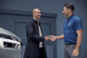 Acheteur recevant les clés d’une voiture d’un vendeur en concession, symbole de la vente automobile